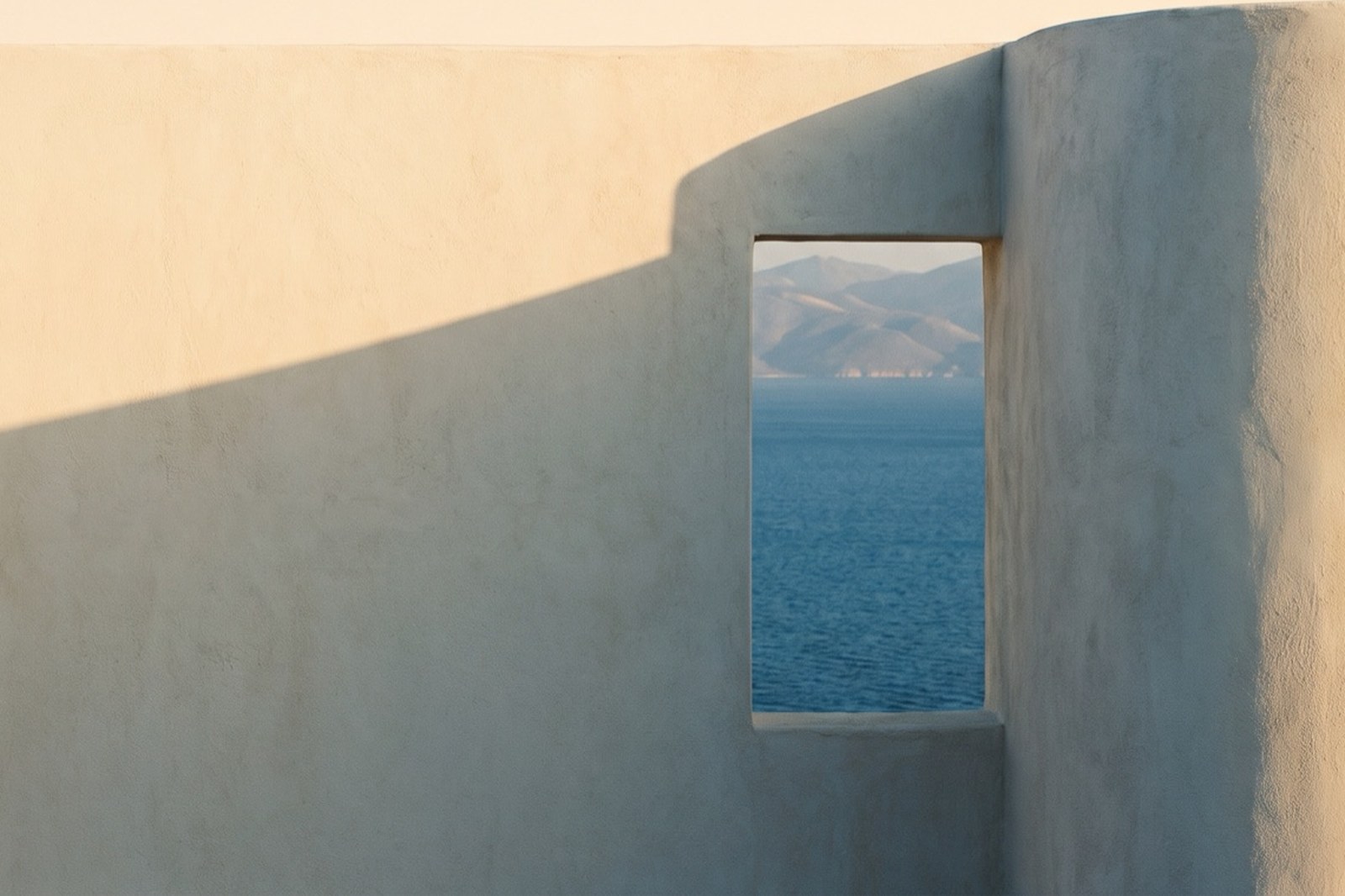 Two whitewashed walls meeting, each in its own light, with an opening between them
