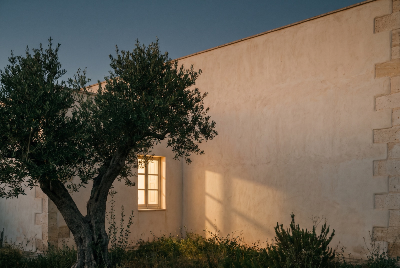 Sala de reuniones con cuatro carpetas idénticas, una por parte, y el Mediterráneo al fondo
